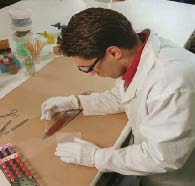 A DNAUI biologist uses a phenolphthalein chemical test to examine a knife for the presence of blood.