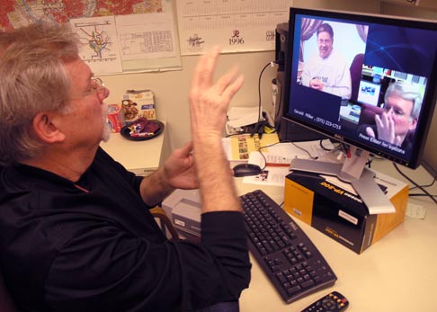 A man using sign language to communicate in a videophone conversation.