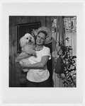 Unidentified woman coal miner, half-length portrait, facing front, at home, holding poodle