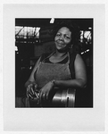 Unidentified African American woman, half-length portrait, facing front, standing at a machine in a Westinghouse factory