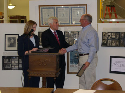 Senator Lugar, assisted by Emmy Huffman, presents a certificate to Jim Ridenour for his participation in the Veterans History Project.