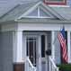 photo of a front porch of a home flying an American flag