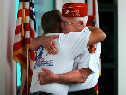 War heroes, Marine Cpl. Robert Glenn, right, and Army Staff Sgt. Rick Chess, embrace after receiving long-overdue Purple Hearts from U.S. Senator Bill Nelson. The medals were delayed by years of red tape that Nelson was able to cut through.  (Fort Pierce Tribune photo)