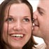 Man whispering in woman's ear (© Piotr Powietrzynski/Getty Images)