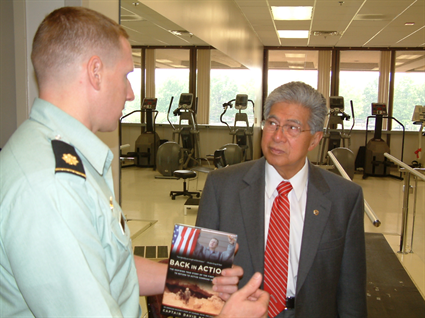 Senator Akaka talks with Major David Rozelle, who lost his right foot in a 2003 land mine explosion in Iraq.  Maj. Rozelle is the first amputee to return to active duty in Iraq.  Despite his injuries, Maj. Rozelle has completed the New York City Marathon, and will compete in the Ironman Triathlon in October 2006 on the Big Island.