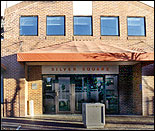 Photograph of the Albuquerque office, a two-story brick building with red awning.