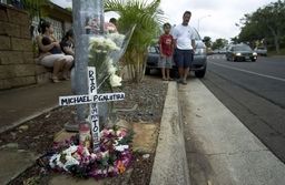 Family members built a roadside memorial for Michael Galutira in Waipahu; he was one of three traffic fatalities on New Year's Day.