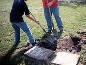 Fifth-grade students at North Cedar School in Mechanicsville help to reset a tombstone at historic Pioneer Grove Cemetery