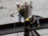 Workers secure a steel beam at a construction site on 8th Avenue and 42nd Street in New York, April 21, 2008.  REUTERS/Shannon Stapleton