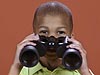 A boy holding a pair of binoculars