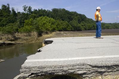 Oakville, Iowa, July 6th, 2008--Lynn Daughtry, Construction Representative for the Army Corps of Engineers surveys additional parts of the road in...
