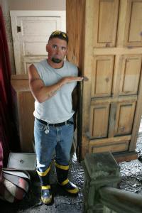 Wapello, Iowa, June 28, 2008 -- Donnie Purdy, 38, shows how high the water level was inside the house by illustrating the mark it left on the book...