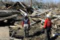 Bolivar Peninsula, TX, December 6, 2008 -- Specially trained cadaver locating dog 'Cooper' (upper left) works a pile of debris while his trainer a...