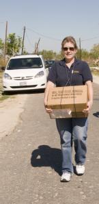 Oak Island, TX, October 25,2008 -- Nancy Weikel, a FEMA community relations employee brings a box of MRE (meals ready to eat) to an Oak Island, TX...
