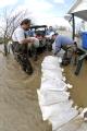 Biscoe, AR, March 26, 2008 -- Locals volunteer in an effort to save houses near the Cache River, a tributary of the White River, which has been ex...