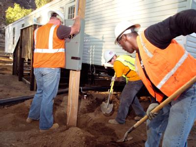 Delzura, CA, December 5, 2007 -- Jim Berkman, of Babcock Services, Inc. holds the pole for the electrical box steady, while electrician Adam Mursc...