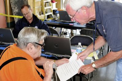 Macon, GA, May 26, 2008 -- Applicant Services Program Specialist (ASP) Michael McComas helping an applicant understand the information on a FEMA f...