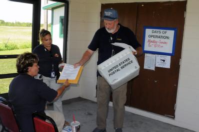 Moore Haven, FL, September 15, 2008 -- FEMA Logistics(LOG) Courier Michael Calahan delivers the mail to Magda Reyes FEMA Disaster Recovery Center(...