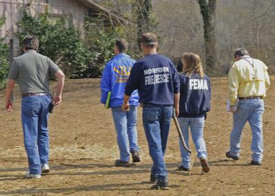 Norfork, AR, March 26, 2008 -- Members of a Preliminary Damage Assessment team walk across a lawn towards a damaged home. The team is comprised of...