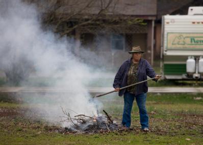 Cape Girardeau, MO, March 29, 2008 -- This resident burns a small pile of debris as she cleans up after the Mississippi River flooding in Cape Gir...