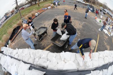 Fenton, MO, March 21, 2008 -- Residents and area volunteers band together to fill sand bags and stack them next to businesses and property on the ...