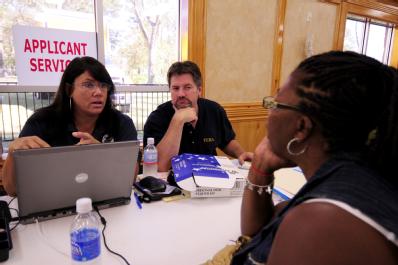 Houston, TX, October 1, 2008 -- Individual Assistance Specialists (IAS) Julie Seaburg (left) and Christopher Urban (right) explain the FEMA recove...
