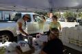Shoreacrea, TX, October 8, 2008 -- Volunteers load the vehicles of local residents with ice, water, and Red Cross lunches at the city hall parking...