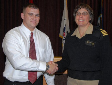 Wounded Marine Corps veteran Sean Locker shakes hands with NSWC Dahlgren Division Commander Capt. Sheila Patterson after she presented the civilian Technical Specialist with a plaque in appreciation of his keynote address to 300 people, comprising military, government civilians and contractors at a Disability Observance event on Oct. 28