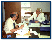 Graphic of two people sitting at a table going over paperwork.
