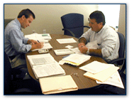 Graphic of two men sitting at a table going through a review.
