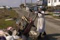 Grand Isle, LA, 11-04-05 -- Mennonite Maria Rudolph from Hogetstown MD emptys trash from a Hurricane Katrina victim.
Mennonite's from across the ...