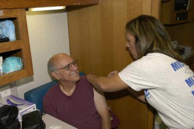 Grand Isle, LA, 11-01-05 -- Lynn Rimer RN of the Disaster Medical Assistance Team (DMAT) from NY4 gives a flu shot to Mark Costanza in the special...