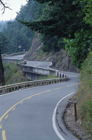 Photograph of a curvy road on a hill side.