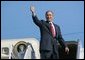 President George W. Bush gives a thumbs up to a crowd of well wishers gathered to see his departure aboard Air Force One at Waco's TSTC Airport in Waco, Texas, Wednesday, Aug. 4, 2004.   White House photo by Eric Draper