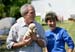 President George W. Bush holds the offspring of a stray dog during a tour of the animal rescue area of the Hands On Network base camp in Biloxi, Mississippi, Thursday, April 27, 2006. Pictured with the President is Disaster Response Coordinator Erika Putinsky.
