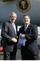 President George W. Bush presented the President’s Volunteer Service Award to David Greenberger upon arrival at the airport in Fort Lauderdale, Florida, on Tuesday, October 24, 2006.  Greenberger is a volunteer with Big Brothers Big Sisters of Broward County.  To thank them for making a difference in the lives of others, President Bush honors a local volunteer, called a USA Freedom Corps Greeter, when he travels throughout the United States.  President Bush has met with more than 500 individuals around the country, like Greenberger, since March 2002.