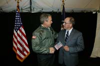 President George W. Bush met Billy C. Colwell, Sr., upon arrival at Fort Campbell, Kentucky, on Thursday, March 18, 2004.  Colwell, a U.S. Army Veteran, is an active volunteer with the Fort Campbell Armed Services YMCA. 