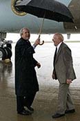 President George W. Bush shares an umbrella and a laugh Thursday, June 2, 2005, at Fort Campbell, Ky., with Freedom Corps greeter Dr. John Cotthoff, an 81-year-old volunteer physician at the St. Luke Free Clinic in nearby Hopkinsville. White House photo by Eric Draper 