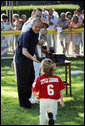 President George W. Bush greets Kassie Frank of Gaithersburg, Md. as he presents her with a baseball Sunday, Sept. 7, 2008, following the final game of Tee Ball on the South Lawn: A Salute to the Troops. White House photo by Grant Miller