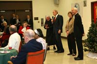 President George W. Bush draws smiles from the audience of volunteers, staff and residents at the Little Sisters of the Poor Tuesday, Dec. 18, 2007, during a visit with Mrs. Laura Bush to the Washington, D.C. facility. Enjoying the moment with them are Mother Benedict de la Passion, Superior and President of Little Sisters of the Poor, and Archbishop Donald Wuerl of the Archdiocese of Washington.