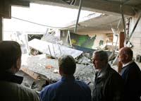 President George W. Bush walks through tornado damage at Enterprise High School in Enterprise, Ala., Saturday, March 3, 2007. The President visited people affected by storms in Americus, Ga., and Enterprise, Ala.