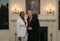 President Bush presents the President's Volunteer Service Award to Marine spouse Kaprece James from Twentynine Palms, California, before the White House celebration of  Military Spouse Day on Tuesday, May 6, 2008. James has been married to Second Lieutenant Rodney James for two years, who is currently deployed to Iraq with Headquarters Company, 3rd Battalion, 4th Marines.  James serves as a volunteer Station Chairman for the American Red Cross Services to the Armed Forces.  In this role, she developed the first year-round Youth Leadership Program to help teenagers enhance their job skills and professional development.  The program also offers classes in first aid, disaster preparedness, and volunteer service opportunities for youth ages 12 to 18.  As the Key Volunteer Coordinator for her husband’s unit, James developed the first battalion newsletter to provide information and encouragement to 250 families of deployed personnel.