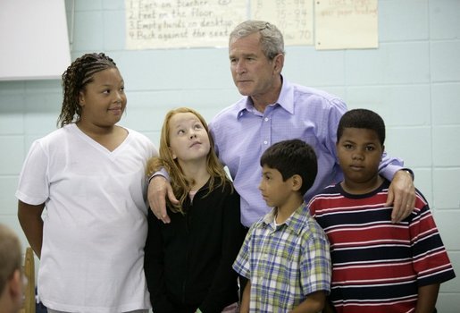 President George W. Bush spends a moment Tuesday, Oct. 11, 2005, with students at Delisle Elementary School in Pass Christian, Miss. The school reopened Tuesday for the first time since Hurricane Katrina devastated the Gulf Coast region. White House photo by Eric Draper