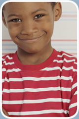 A young boy smiles at the camera.