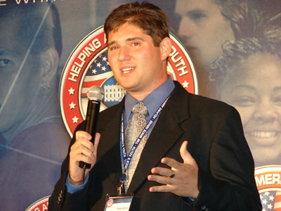 Curtis presenting on stage with HAY logo in background