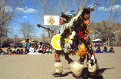 Photo of Indian dancers performing on school playground with student audience.