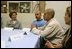 Laura Bush talks with, from left, Gabriel Flores, Archie Dominguez and Shirley Torres during a discussion at Homeboy Industries in Los Angeles April 27, 2005. Homeboys Industries is an job-training program that educates, trains and finds jobs for at-risk and gang-involved youth.