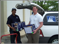 Robert McDougald, left, an accountable property officer with the  Federal Emergency Management Agency, helps Moniteau School District Network  Administrator Andrew Stabb load his vehicle with one of the 28 surplus computer  printers the federal agency donated to the district, in accordance with federal  surplus property disposal procedures.