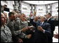 President George W. Bush gestures the "hook'em horns" sign of the University of Texas to U.S. military personnel in the balcony, as he meets with U.S. military and diplomatic personnel Sunday, Dec, 14, 2008, at the Al Faw Palace-Camp Victory in Baghdad. White House photo by Eric Draper