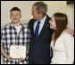 President George W. Bush congratulates U.S. Army PFC Joseph Devan of Baltimore, Md., after presenting him with a Purple Heart Monday, Dec. 22, 2008, during a visit to Walter Reed Army Medical Center, where soldier is recovering from injuries suffered in Operation Iraqi Freedom. With them is PFC Devan's wife, Stephanie. White House photo by Eric Draper